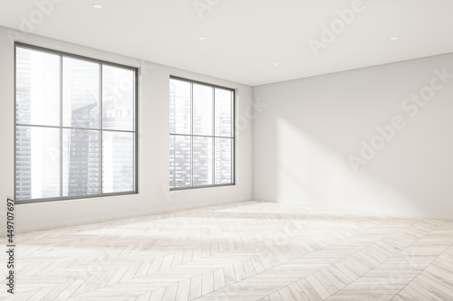 Empty white room with light wood floor and windows. Corner view.