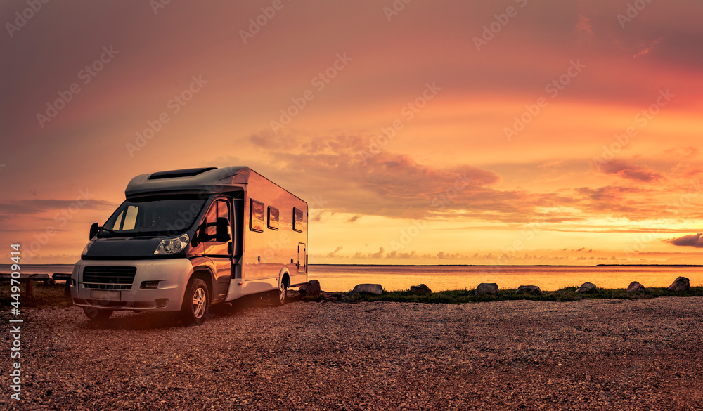 Woman at sunset  with mobile home on the beach