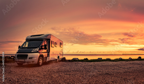 Woman at sunset  with mobile home on the beach