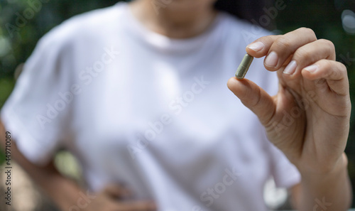 Close Up woman holding pill  capsule Andrographis paniculata in hand