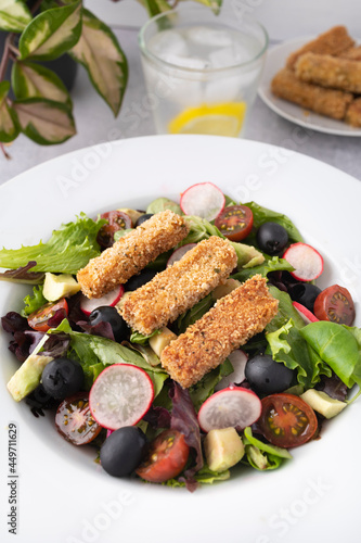 Green leafy salad, tomato, avocado, radishes, olives and tofu fingers. Vegetarian salad. Vegan food photography