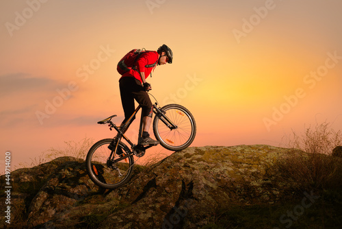 Cyclist in Red Riding Bike on the Spring Rocky Trail at Sunset. Extreme Sport and Enduro Biking Concept. © Maksym Protsenko