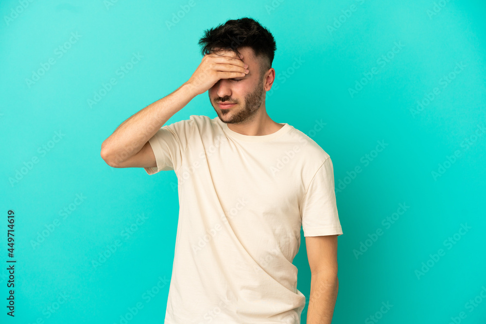 Young caucasian man isolated on blue background with headache Young caucasian man isolated on blue background with headache