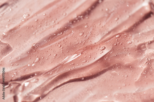 Foto Liquid gel or serum drops  on pink background in macro.