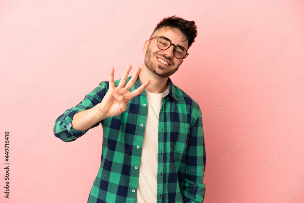 Young caucasian man isolated on pink background happy and counting four with fingers Young caucasian man isolated on pink background happy and counting four with fingers