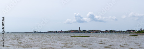 Panoramic view from the shore line area close to West-Terschelling towards the town with clearly visible the iconic lighthouse Brandaris on a clear day in summer photo