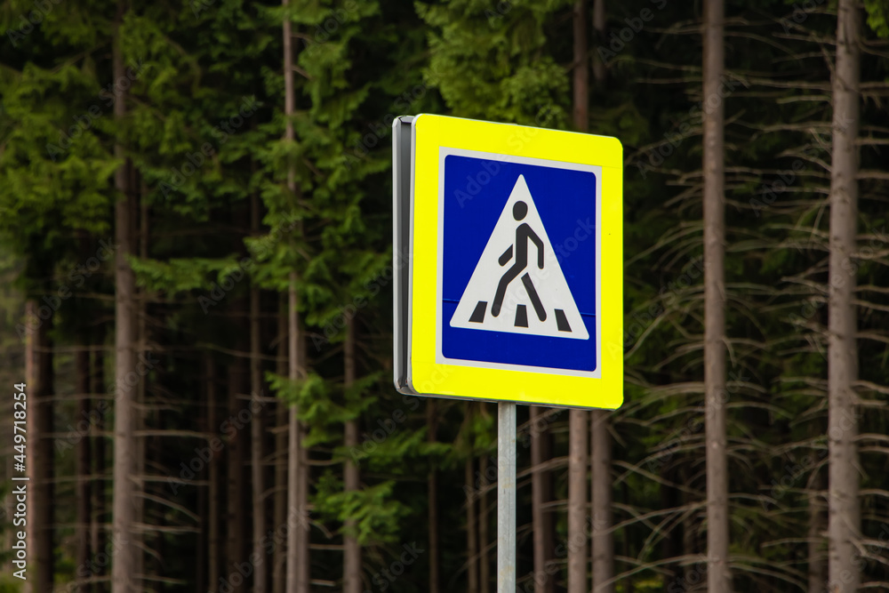 Pedestrian crossing sign on forest background