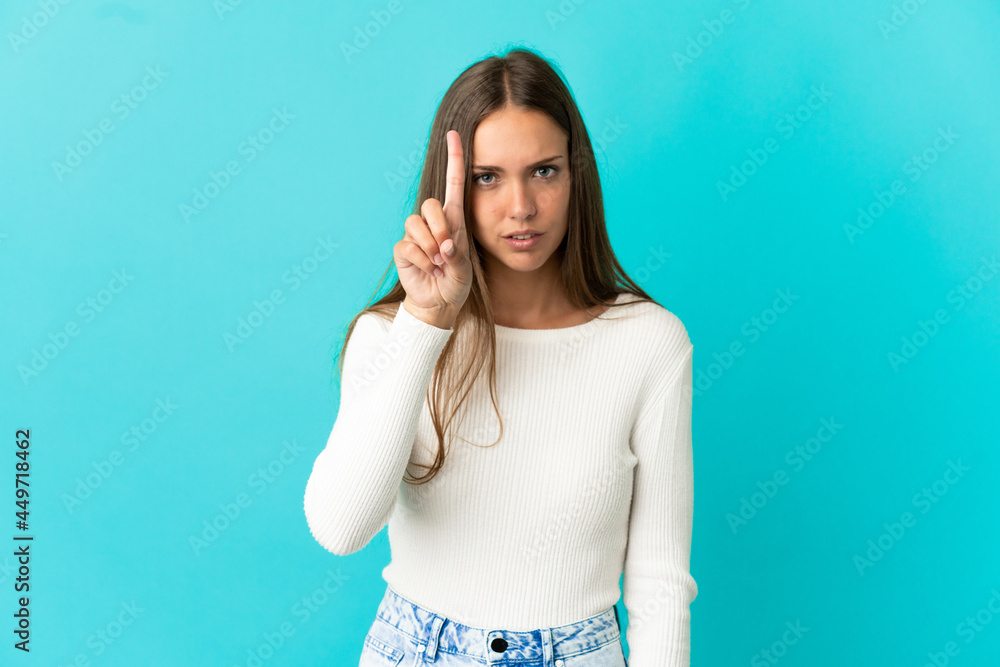 Young woman over isolated blue background counting one with serious expression Young woman over isolated blue background counting one with serious expression