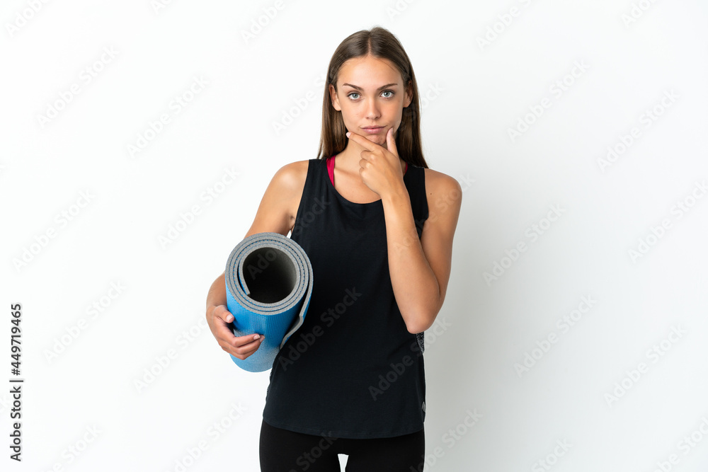 Sport woman going to yoga classes while holding a mat over isolated white background thinking Sport woman going to yoga classes while holding a mat over isolated white background thinking