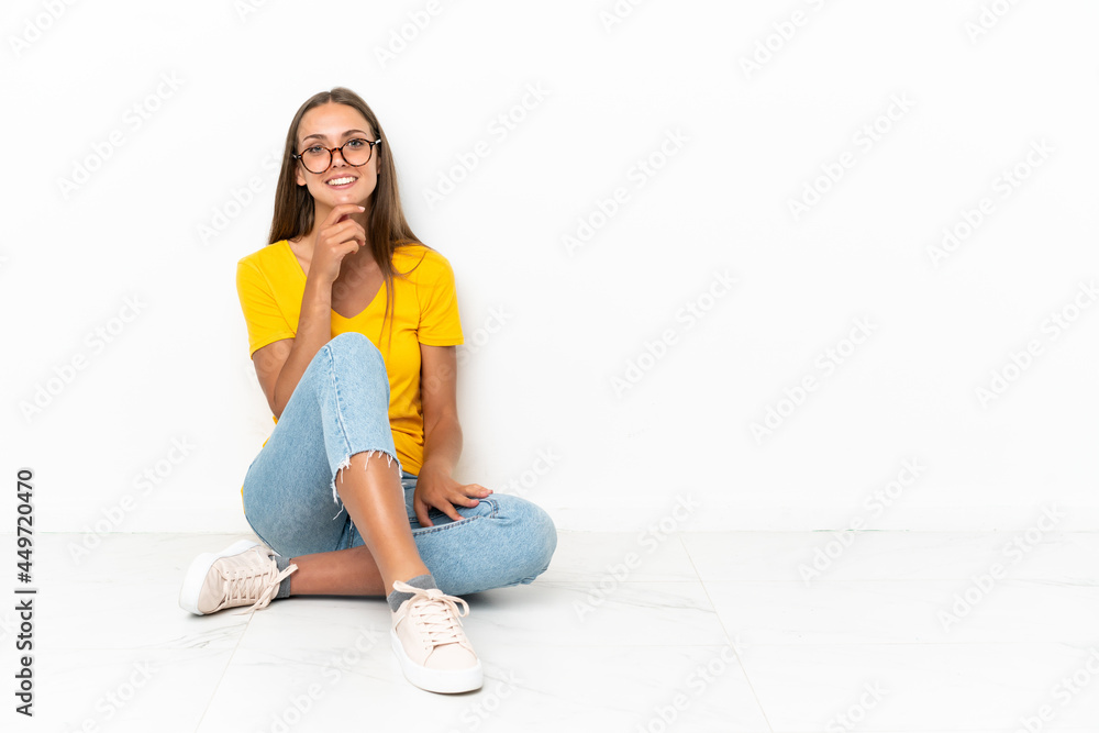 Young girl sitting on the floor with glasses and smiling Young girl sitting on the floor with glasses and smiling
