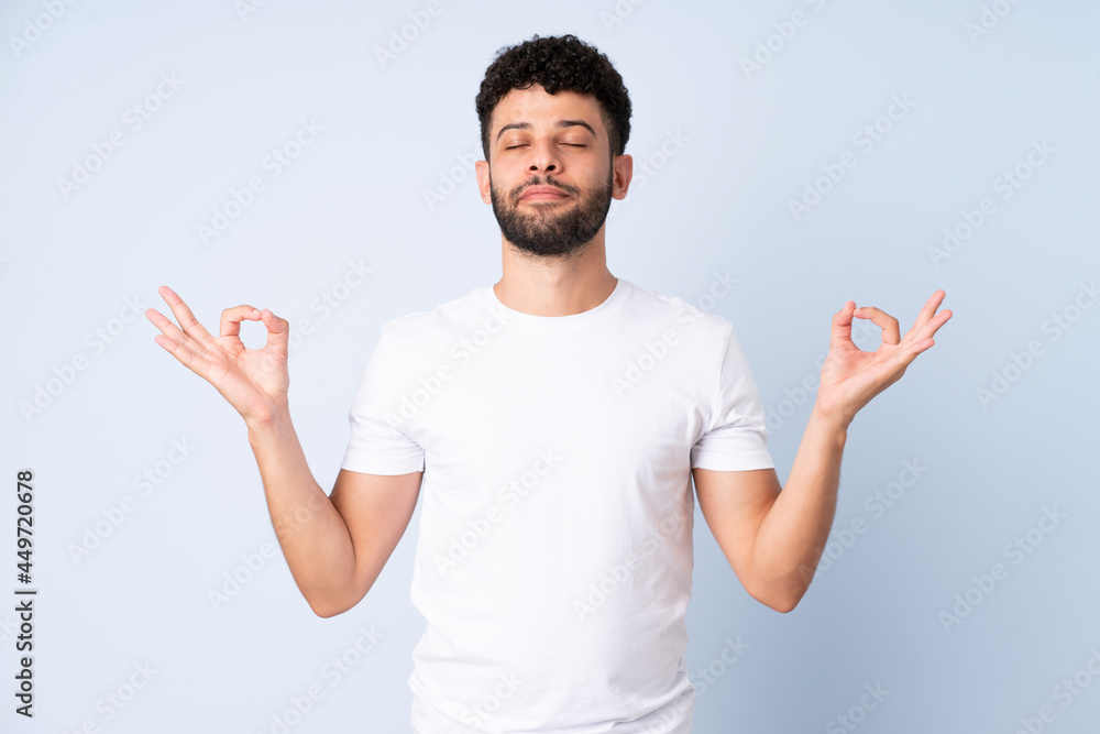 Fototapeta premium Young Moroccan man isolated on blue background in zen pose