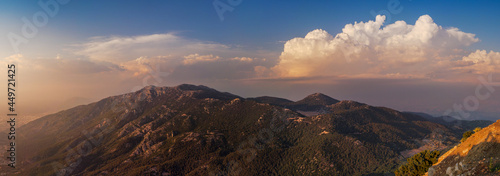 Sunset light over hills around of the Babadag mountain, panoramic view. Wide landscape with mountains and beautiful clouds on top viewpoint in Fethiye.