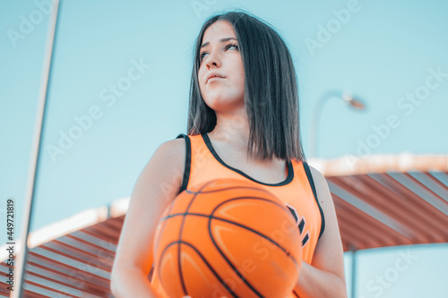 Mujer intrigada y joven jugando al baloncesto con una pelota en una pista de juego para encestar el balon en la canasta photo