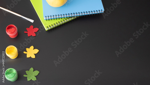 Art supplies and school supplies on a black school board. View from above. Place for your text.