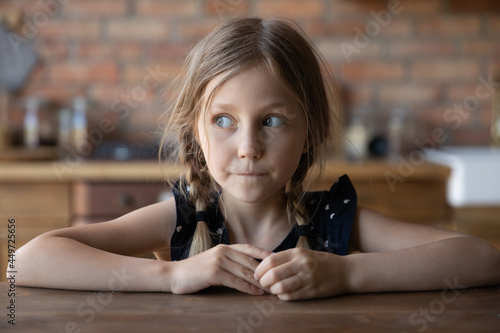 Konstfotografi Head shot portrait of sly little girl with guilty scared face and shut mouth