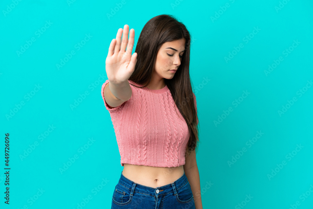 Young Brazilian woman isolated on blue background making stop gesture and disappointed Young Brazilian woman isolated on blue background making stop gesture and disappointed