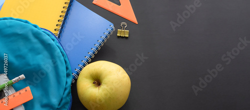 School supplies on a black school board. Back to school concept.