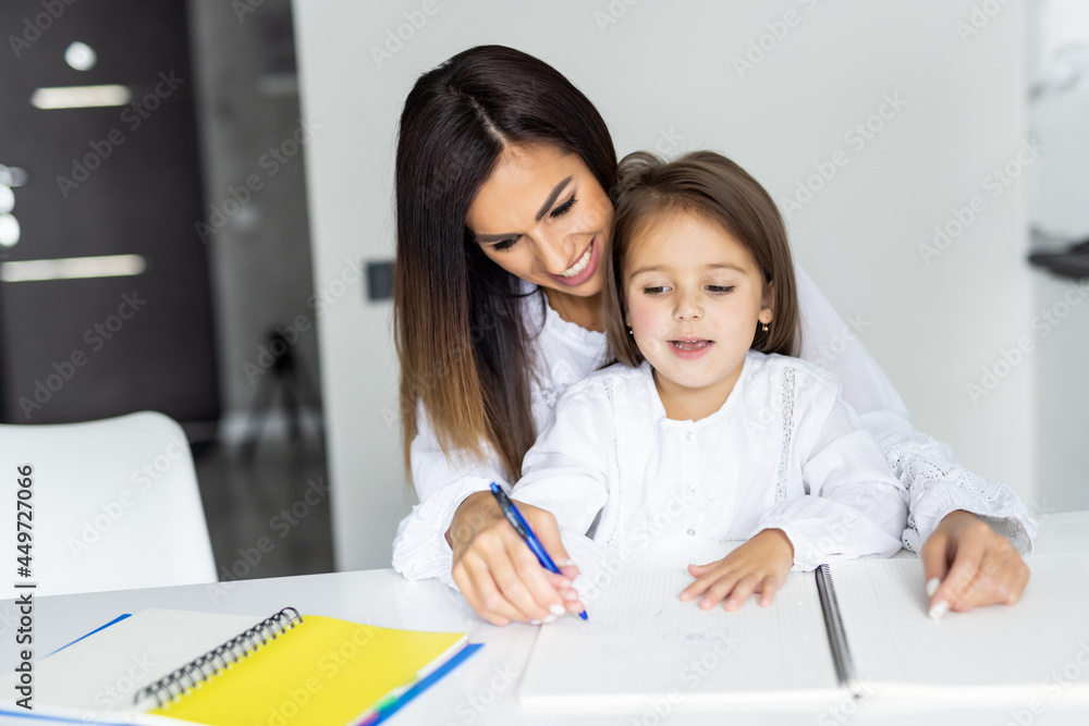 Parent helps the child to do homework.Mother learning her daughter Parent helps the child to do homework.Mother learning her daughter