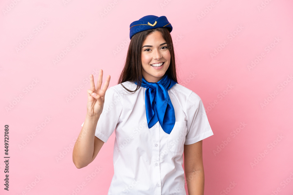 Airplane stewardess Brazilian woman isolated on pink background happy and counting three with fingers Airplane stewardess Brazilian woman isolated on pink background happy and counting three with fingers