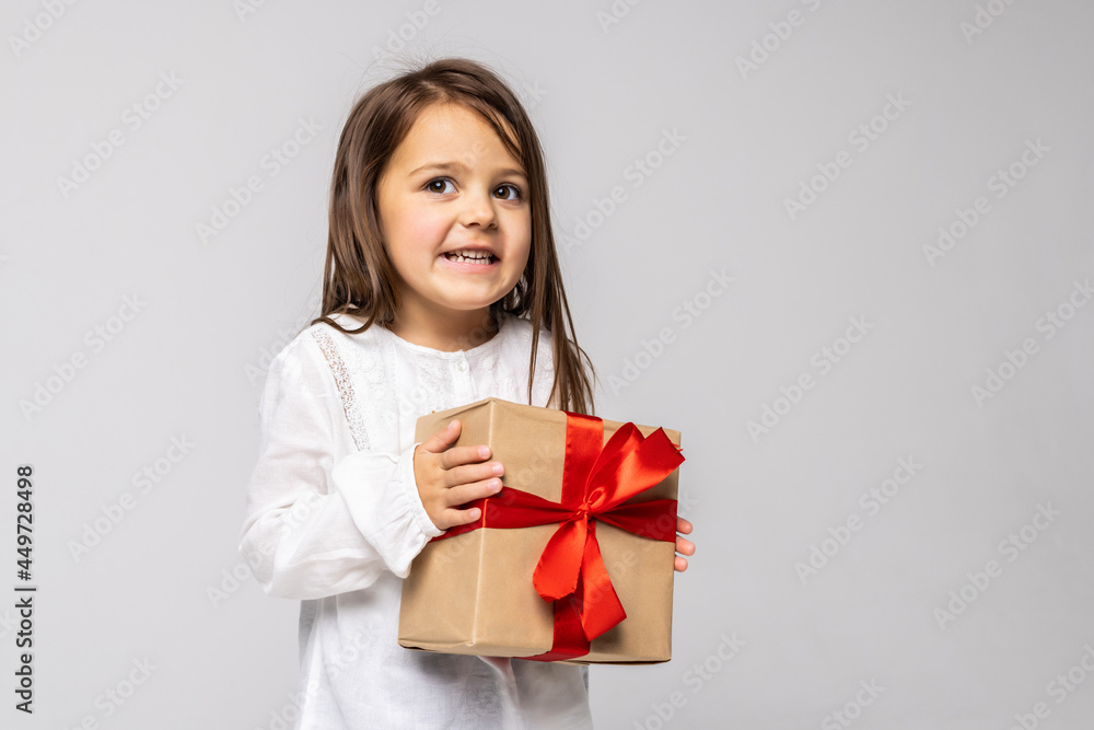 Happy little girl with gift isolated on white background. Kid with gift concept. Happy little girl with gift isolated on white background. Kid with gift concept.