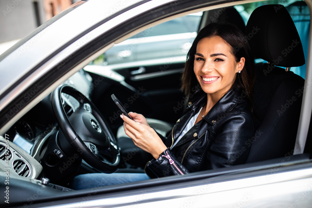 Young girl uses a mobile phone in the car. Technology cell phone isolation. Internet and social media. Woman with smartphone in her car. Young girl uses a mobile phone in the car. Technology cell phone isolation. Internet and social media. Woman with smartphone in her car.