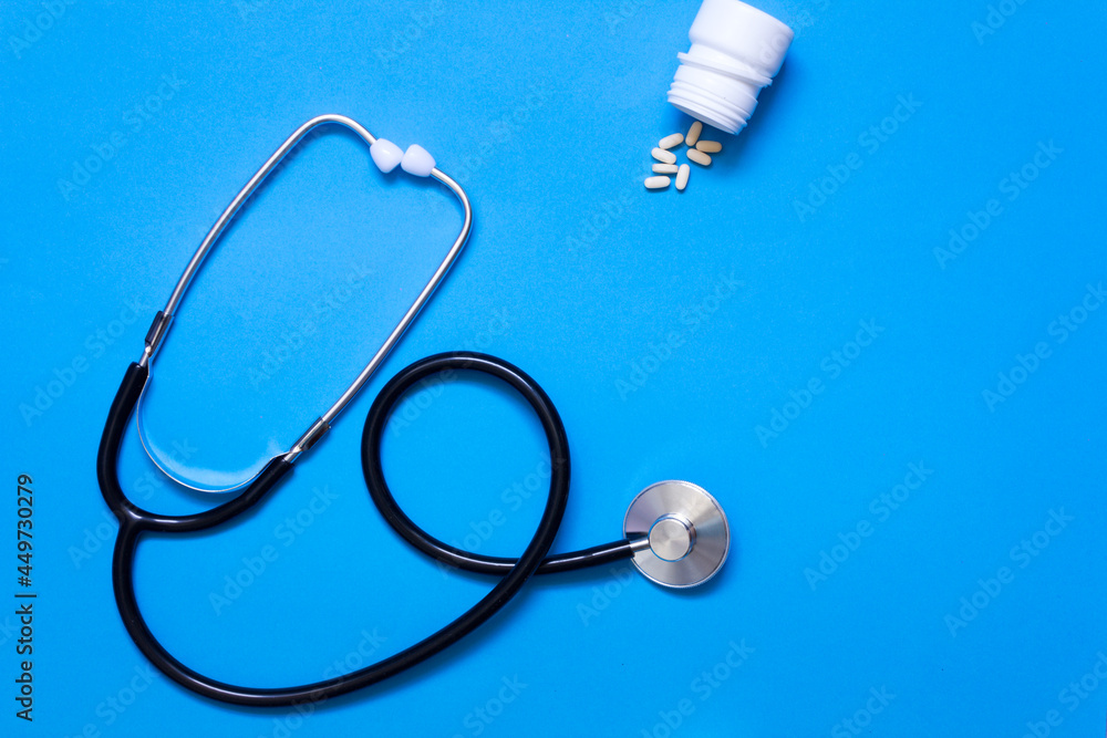 Stethoscope and pills on blue background Stethoscope and pills on blue background