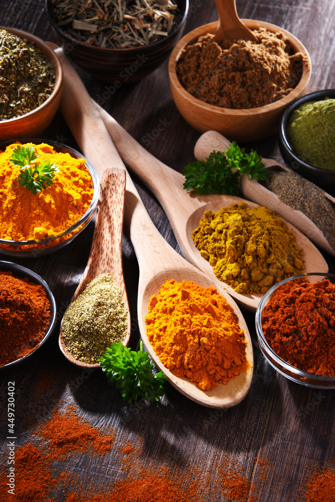 Variety of spices on wooden kitchen table.