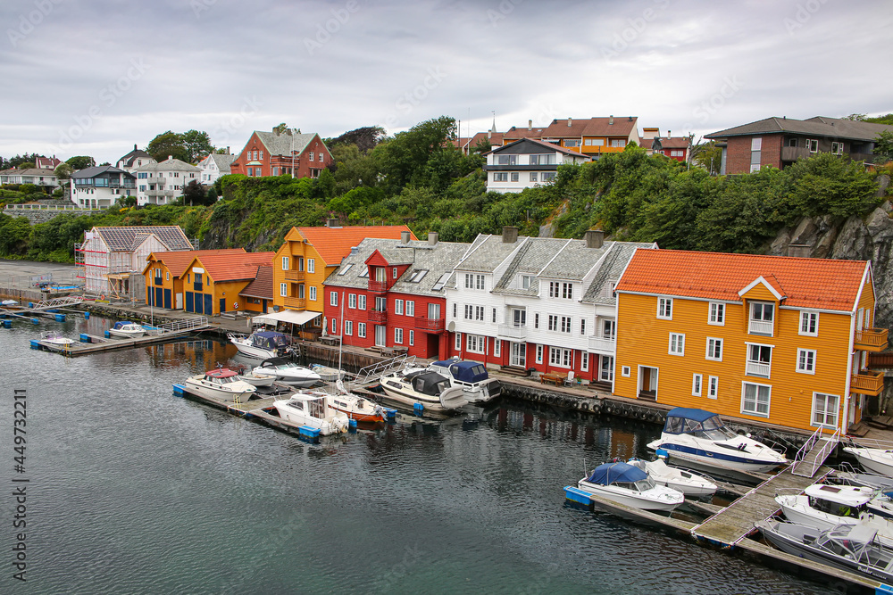 Traditional wooden buildings along the waterfront and the marina. Smedasundet area and river in the center of the town. Surrounded by traditional buildings and boats in the water, Haugesund, Norway.