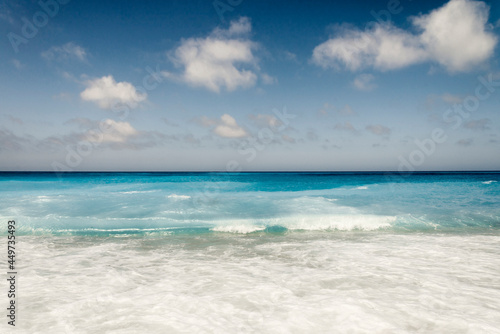 Tropical sand beach and blue sky, hot summer day, waves on the beach, retro tones © malija