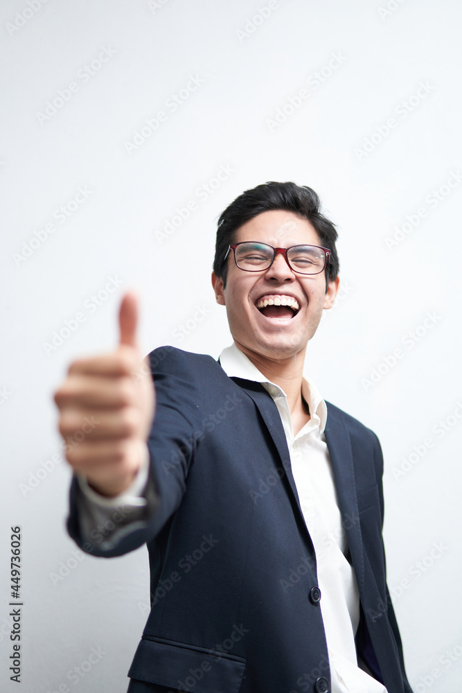 young latin man in suit laughing out loud with thumb up, ok sign of approval, on a white background young latin man in suit laughing out loud with thumb up, ok sign of approval, on a white background