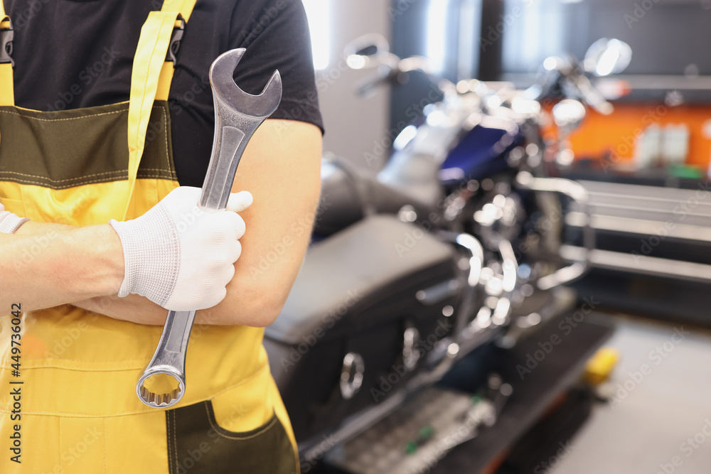 Locksmith master holds wrench in garage closeup Locksmith master holds wrench in garage closeup