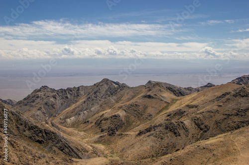 Beautiful Summer scenery  yellow and brown mountains under the blue cloudy sky. Central Asian mountain background. 