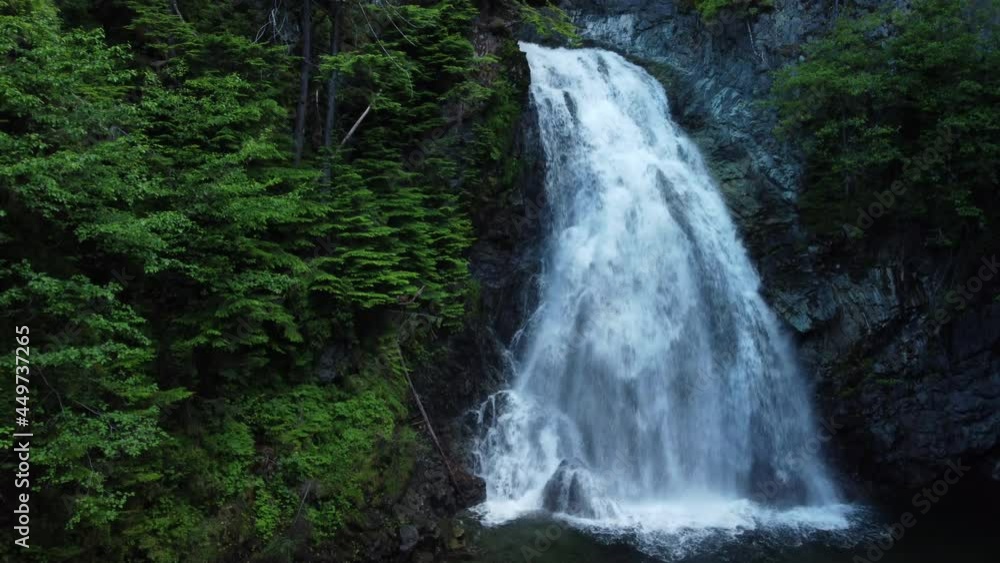 A crane up reveal of a waterfall in a forest A crane up reveal of a waterfall in a forest