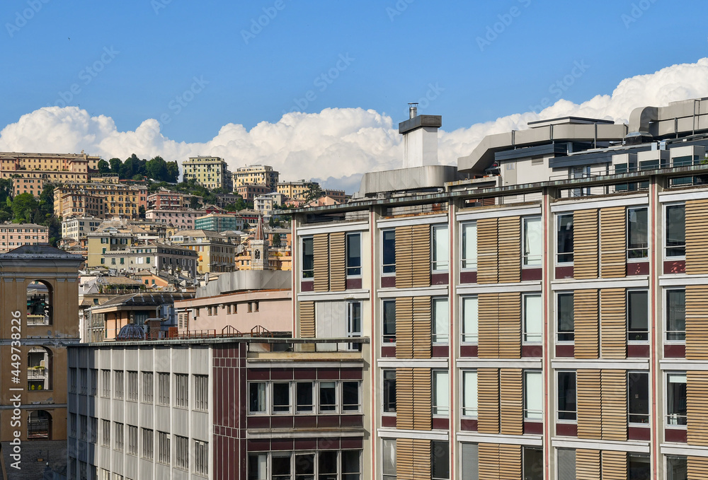 Rooftop view of the city center of Genoa with modern buildings and the hill in the background in a sunny day, Liguria, Italy