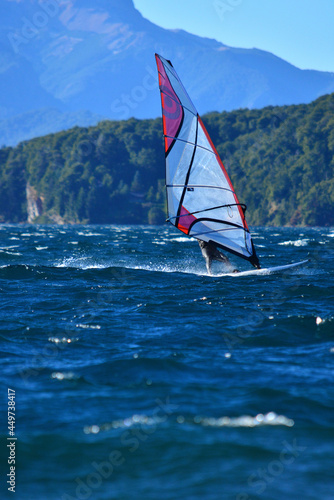 practicing windsurfing in a Patagonian lake with blue waters