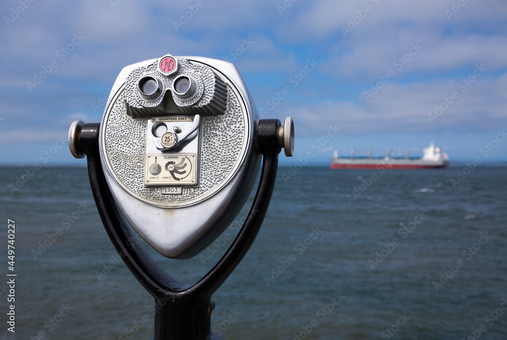 Retro coin-operated binoculars - also known as tourist binoculars - point to a large ship off the coast of Westport, WA
 - obrazy, fototapety, plakaty 