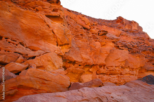 a beautiful view of a mountain desert canyon of red color against the background of a blue sky and a scorching sun