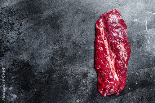 Raw Hanging Tender beef meat steak. Black background. Top view. Copy space