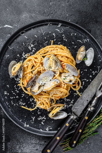 Seafood Spaghetti pasta with Clams vongole in a plate. Black background. Top view
