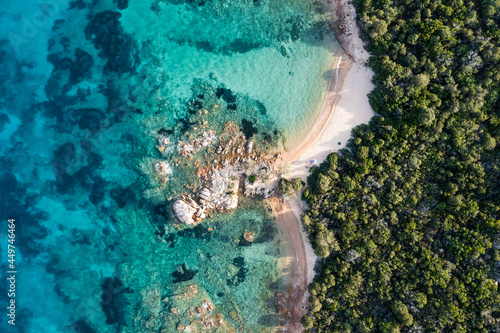 View from above, stunning aerial view of a green coastline with some empty beaches bathed by a beautiful and turquoise sea. Liscia Ruja, Costa Smeralda, Sardinia, Italy.