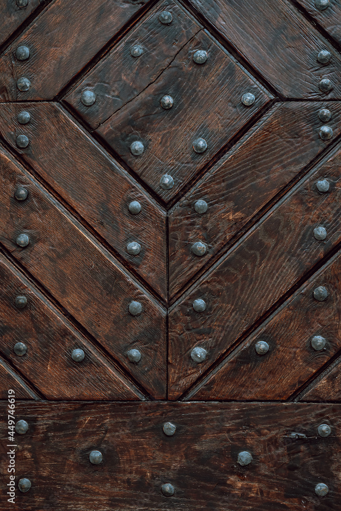 Wooden door with iron handles. Ancient wooden door. Detail of a wooden background. Wooden door with iron handles. Ancient wooden door. Detail of a wooden background.