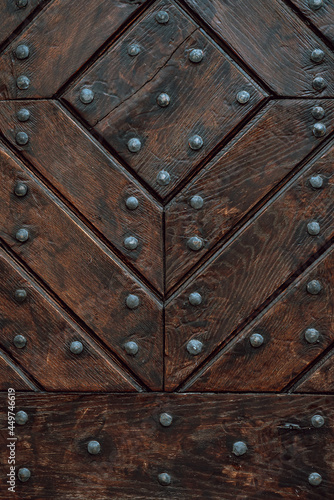 Wooden door with iron handles. Ancient wooden door. Detail of a wooden background.