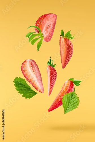 Fototapeta Naklejka Na Ścianę i Meble -  Fresh raw ripe strawberry with green leaves falling in the air, food levitation