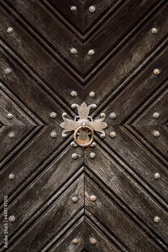 Wooden door with iron handles. Ancient wooden door. Detail of a wooden background.