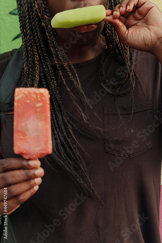 Person holding and eating frozen popsicles   photo