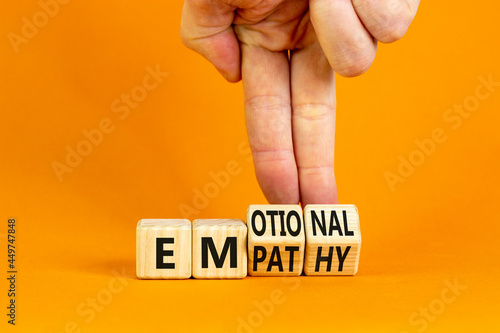 Emotional empathy symbol. Doctor turns wooden cubes and changes the word 'Emotional' to 'Empathy'. Beautiful orange table, orange background, copy space. Psychology, emotional empathy concept. photo
