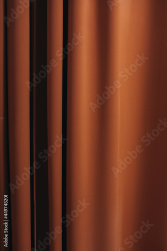 Background texture of orange material curtains. Details of a cozy home interior in autumn shades. vertical