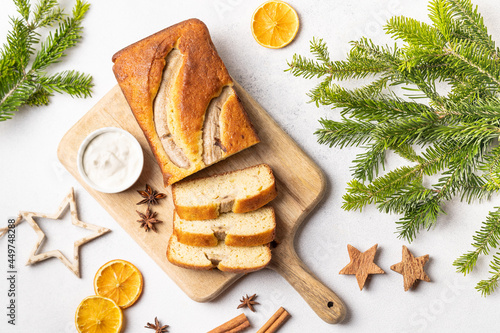 Crispy banana bread with cinnamon on a gray concrete background. Christmas or New Year's dessert. Christmas tree branches.