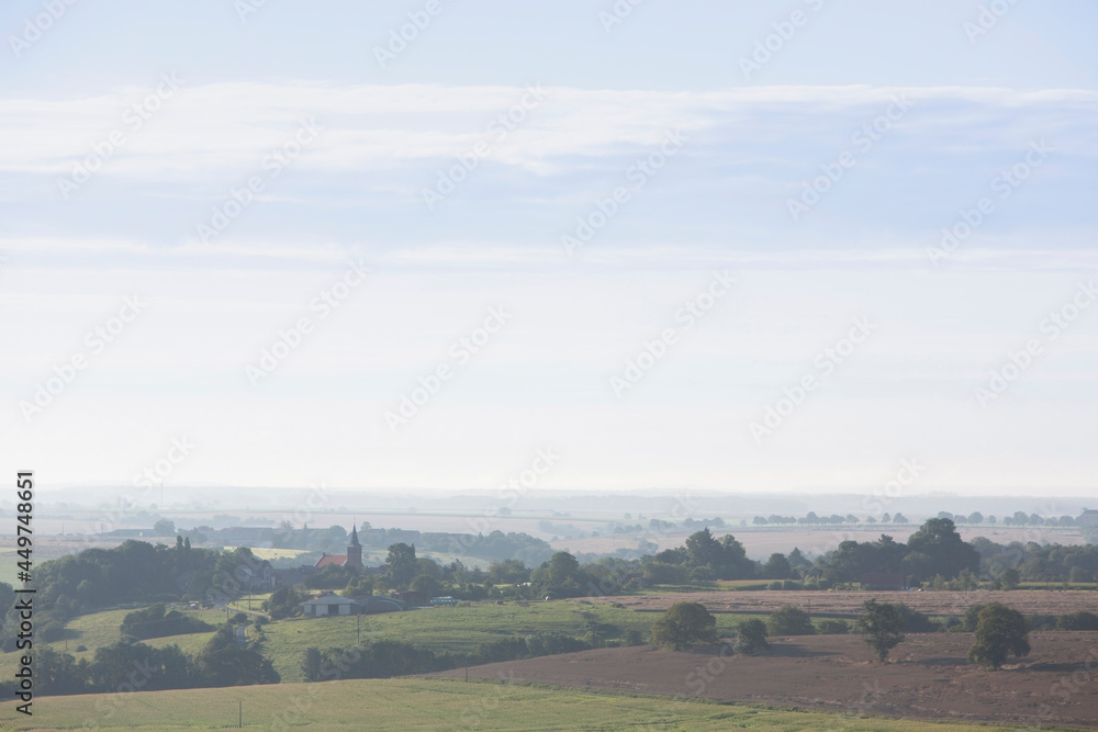 village in foggy countryside of french ardennes region