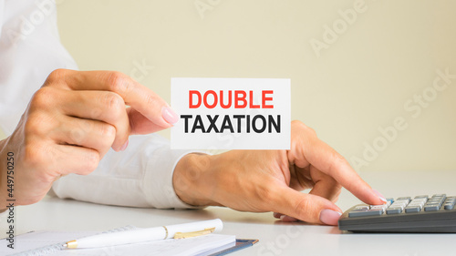 double taxation  message on business card shown by a woman